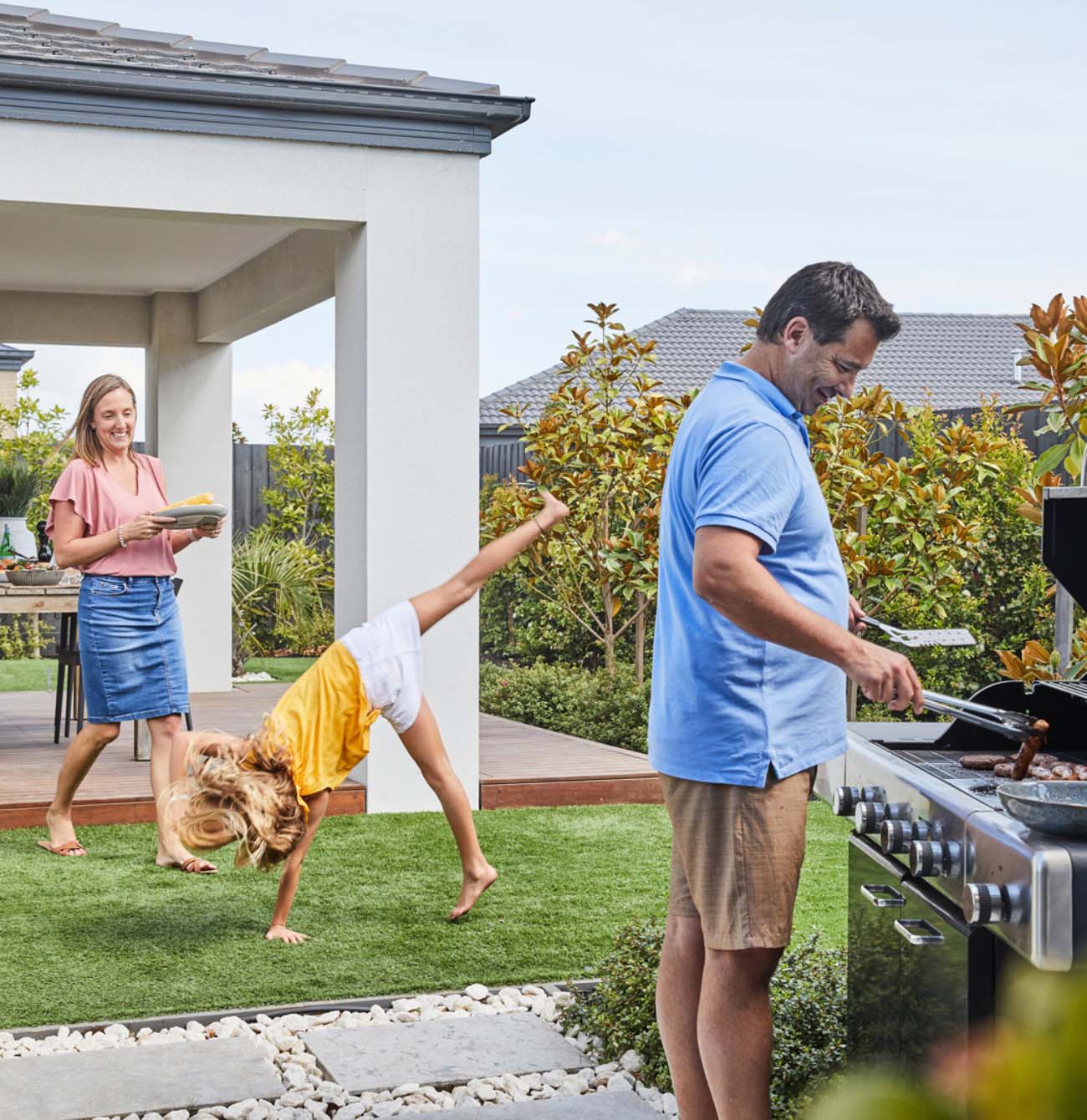 Young family enjoying a BBQ in their own back yard