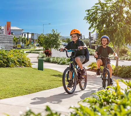 Ridgeview, Narangba entrance statement with young children riding bikes to school.