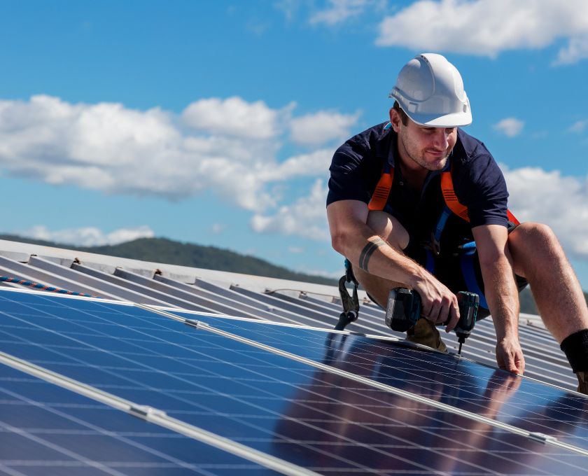 Allara, Eglinton solar installation, man drilling solar panels into roof.