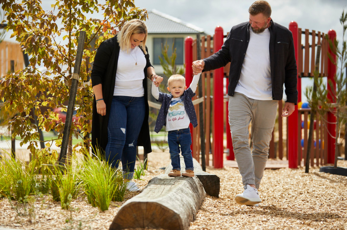 Botanical, Mickleham young family hold their child's hand while balancing along playground equipment.