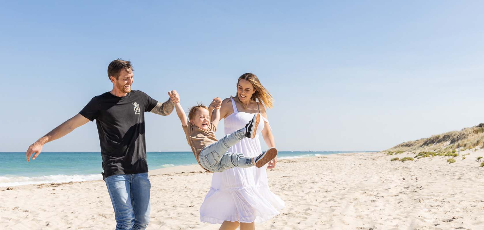 Eden Beach, Jindalee, father, mother and son walking along the coast