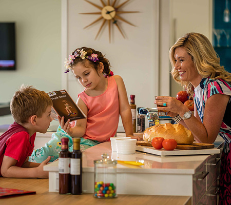 Smithfield Village, Smithfield mother with daughter and son sitting around the kitchen enjoying their new home.