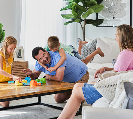 Maple Grove, Pakenham young family sitting around coffee table playing a board game.
