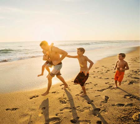 Ocean Hill, Lakelands, family running along the sand at the beach
