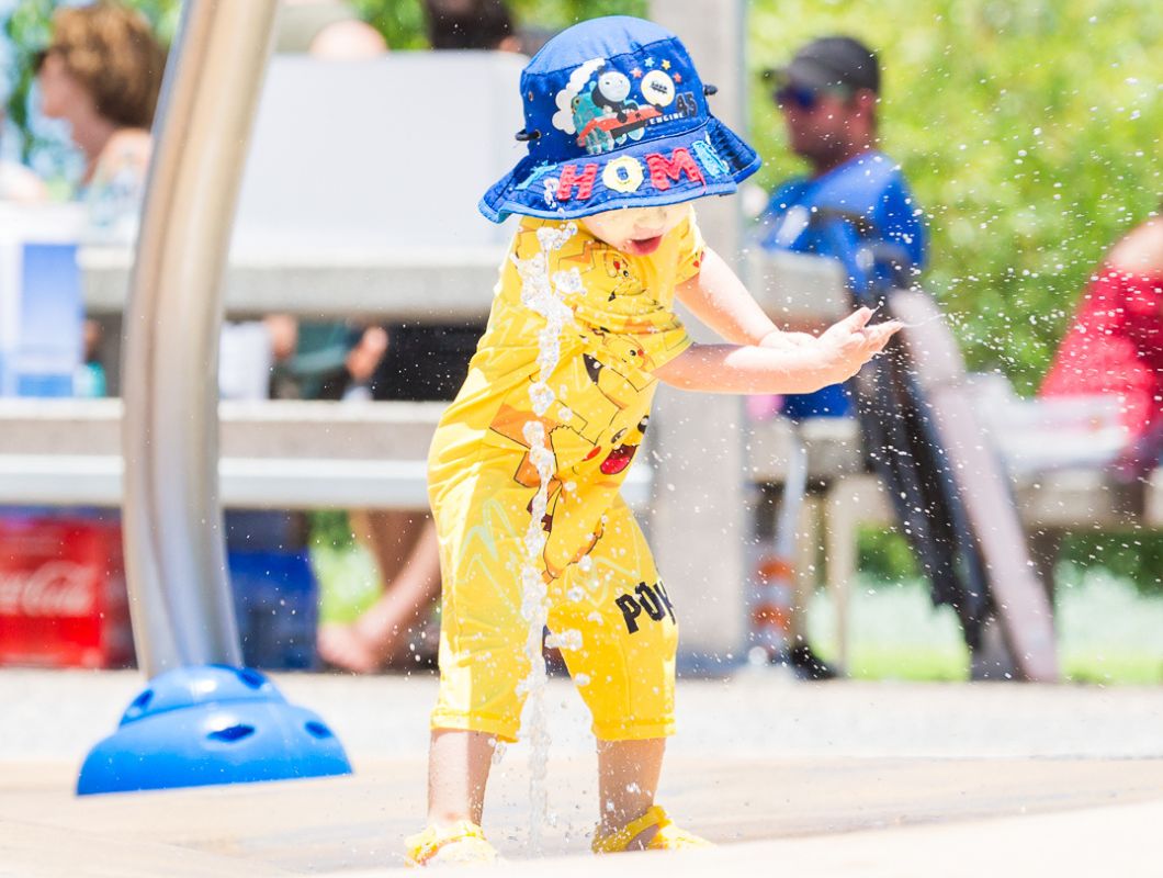Allara, Eglinton Revolution park young child splashing through the waterplay.