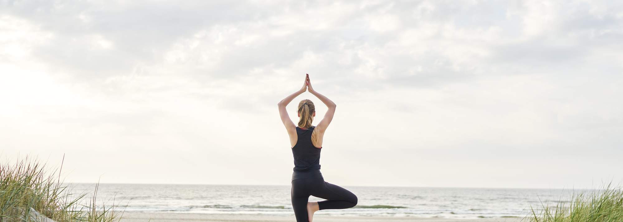 Eden Beach, Jindalee, young woman completing yoga on the beach