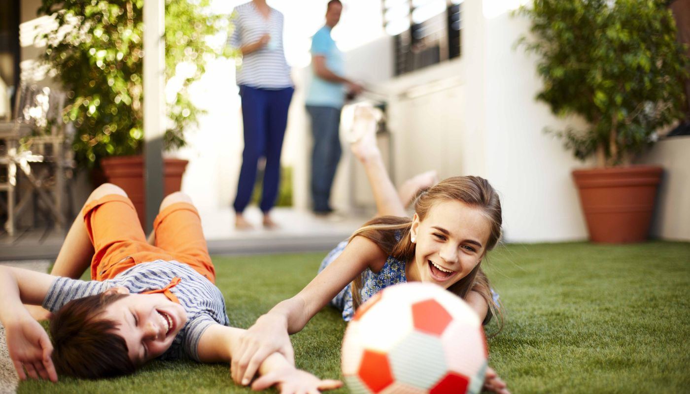Eden Beach, Jindalee, young family playing in the back yard with a soccer ball