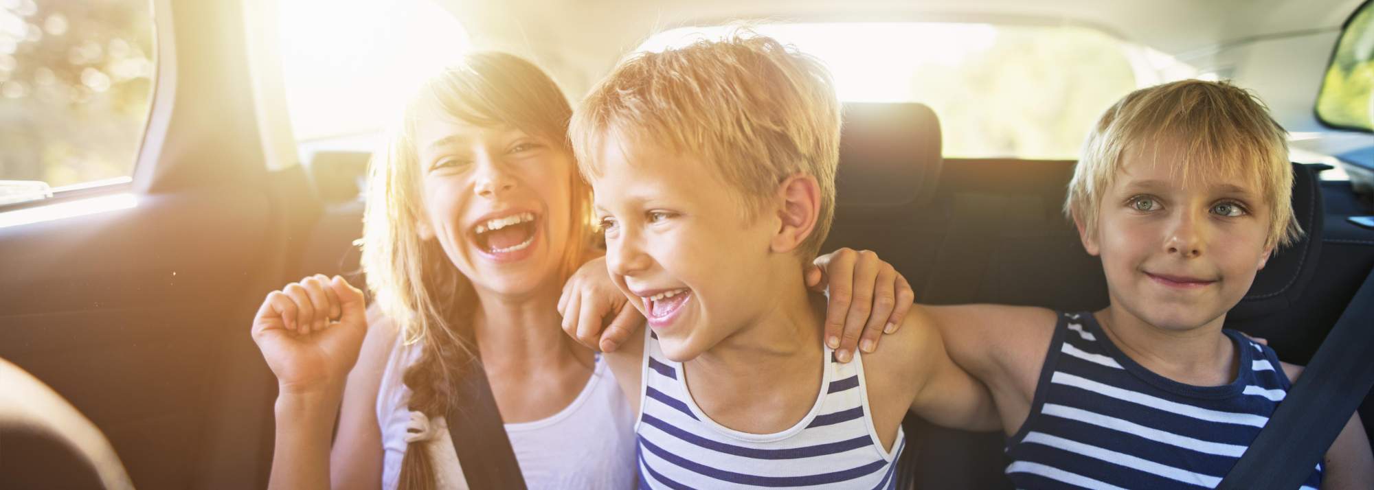 Young children riding in the back of a car