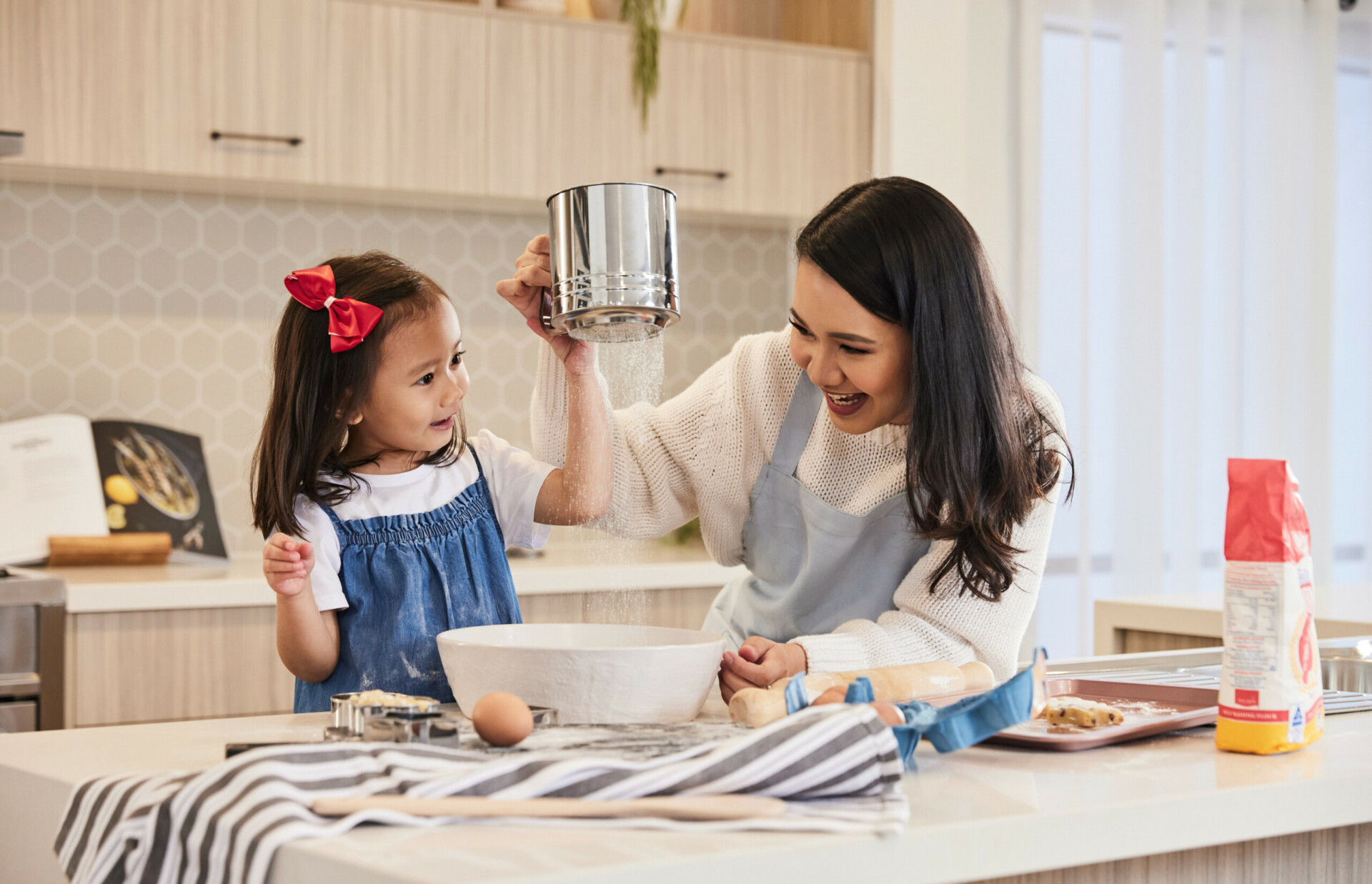 Mother and young daughter baking in the kitchen