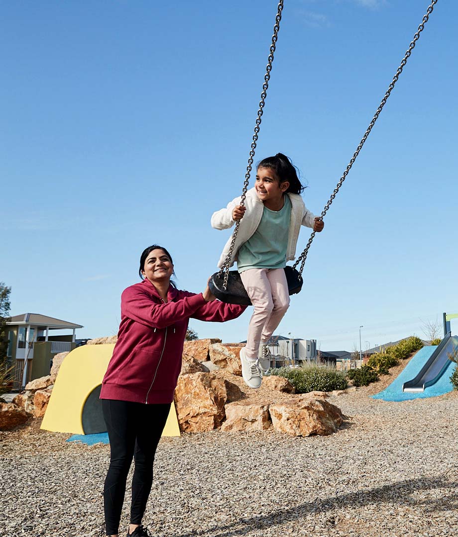 Botanical, Mickleham mother pushing young daughter on swing set.