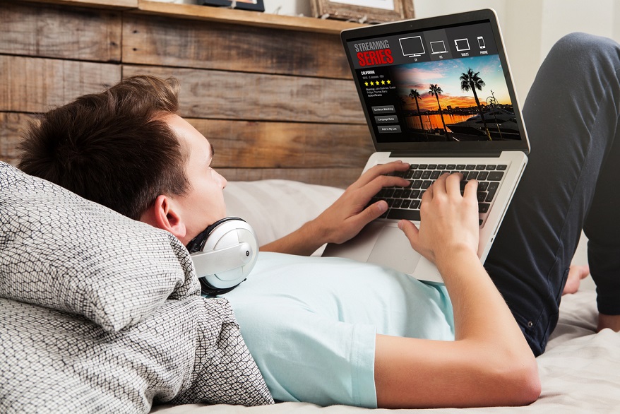 Internet and TV young man watching streaming service on laptop