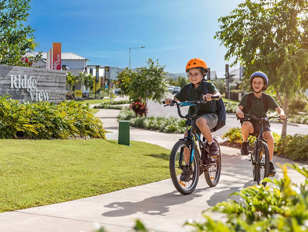 Ridgeview, Narangba entrance statement with young children riding bikes to school.