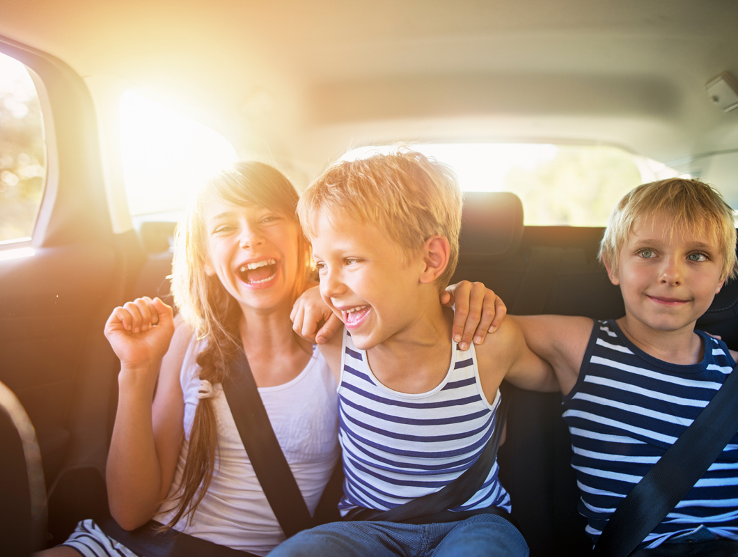 Smithfield Village, Smithfield three children in the backseat of a car, laughing and smiling.
