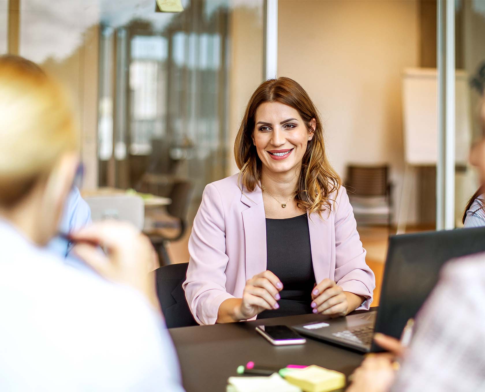Woman talking business with laptop and phone in hand