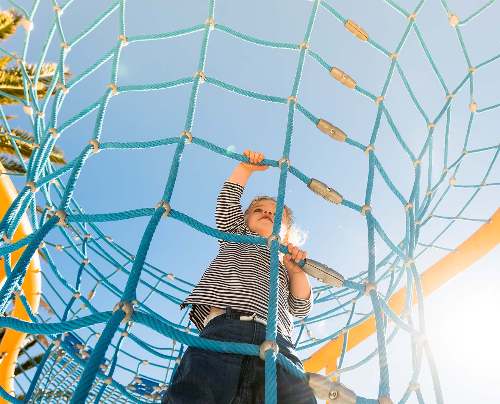 Young child climbing play equipment at work