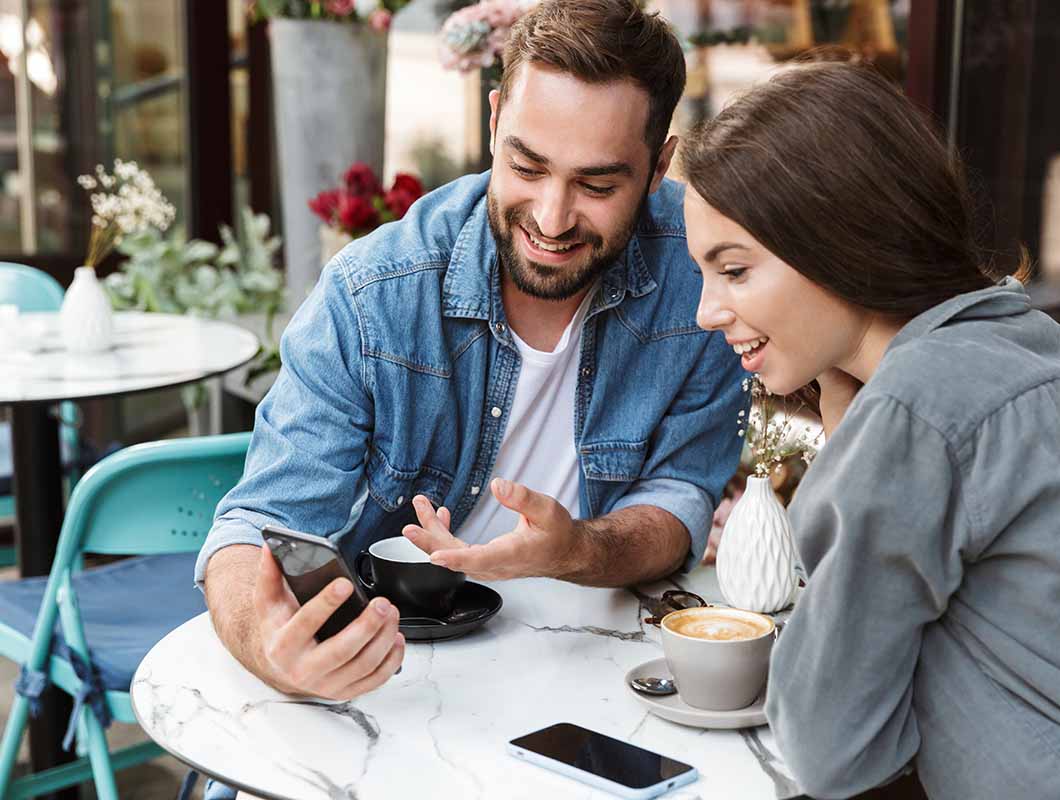 Young couple sitting at cafe on the phone