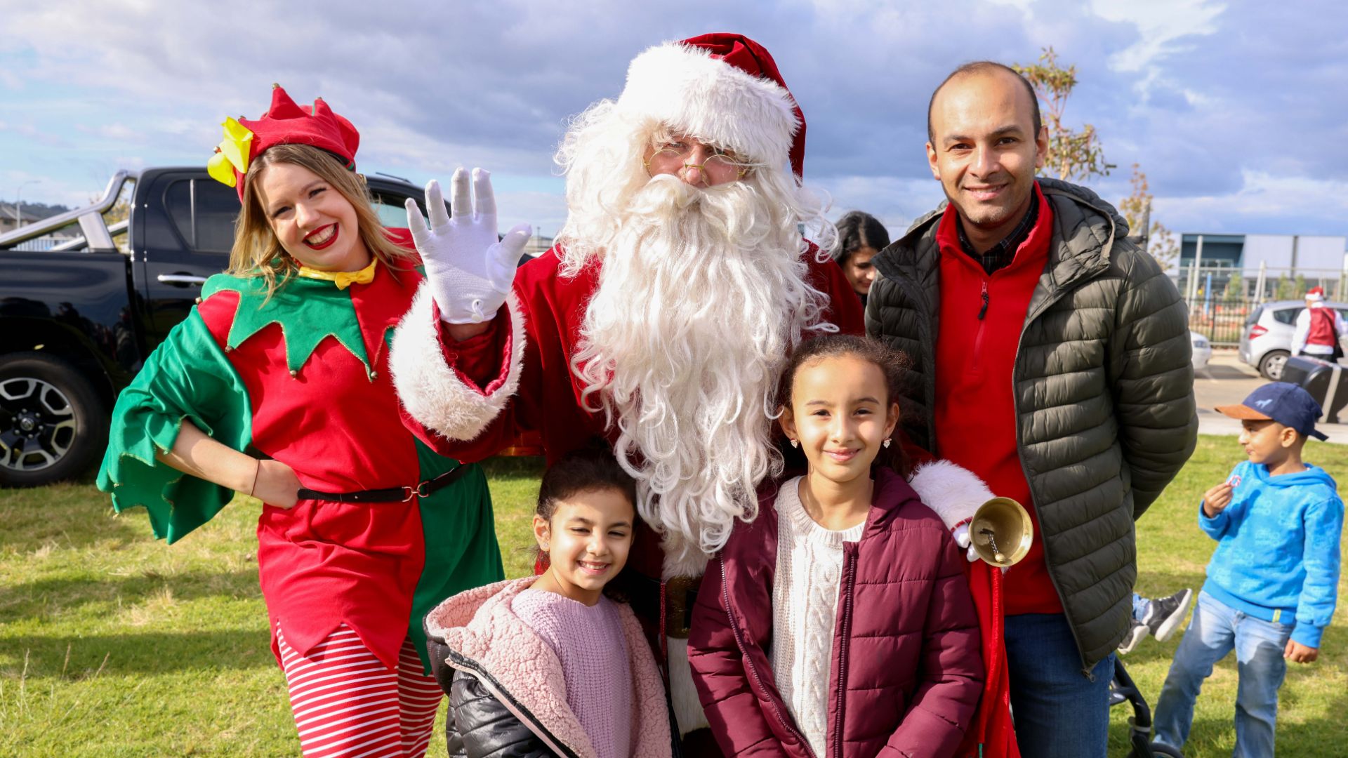 Arcadia, Officer Santa clause, his helper and young family smiling for a photo