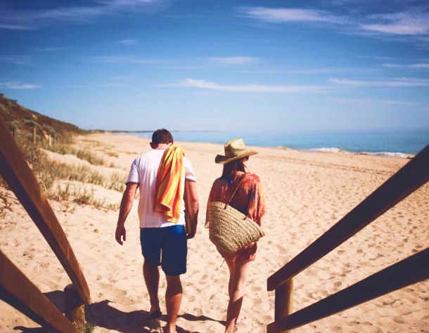 Young couple walking down towards the beach