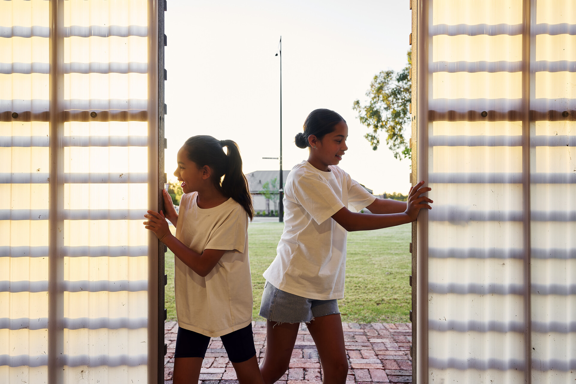 Young children walking through the restored shed and community space