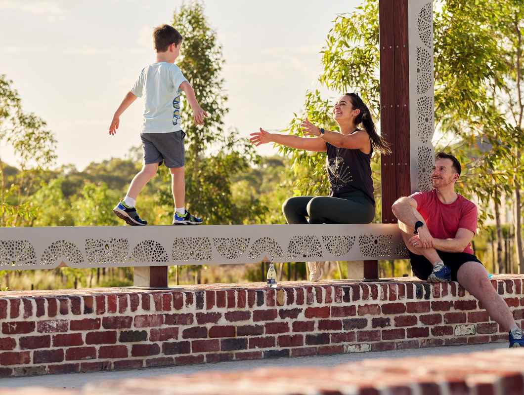 Young family sitting outside along the sculpture at Clementine