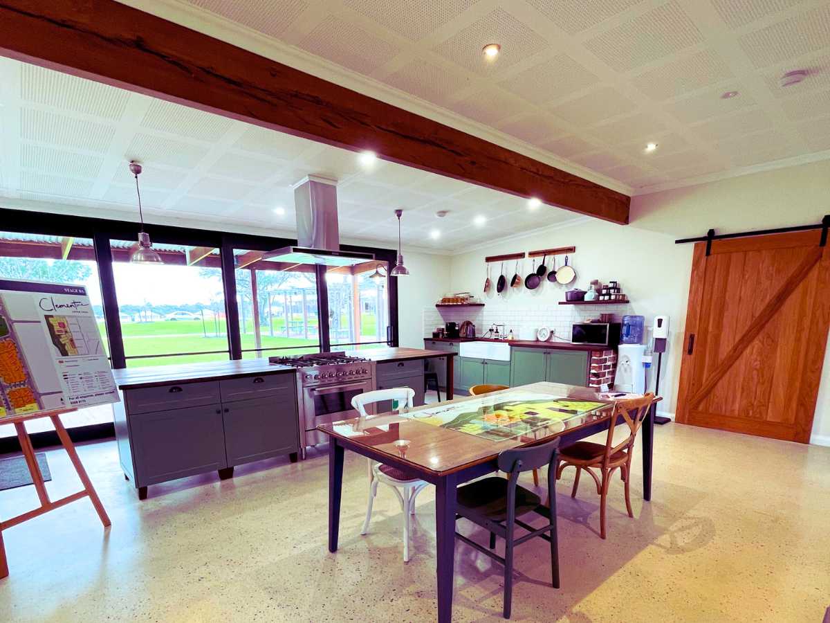 Dining table and open plan kitchen in a rustic cottage