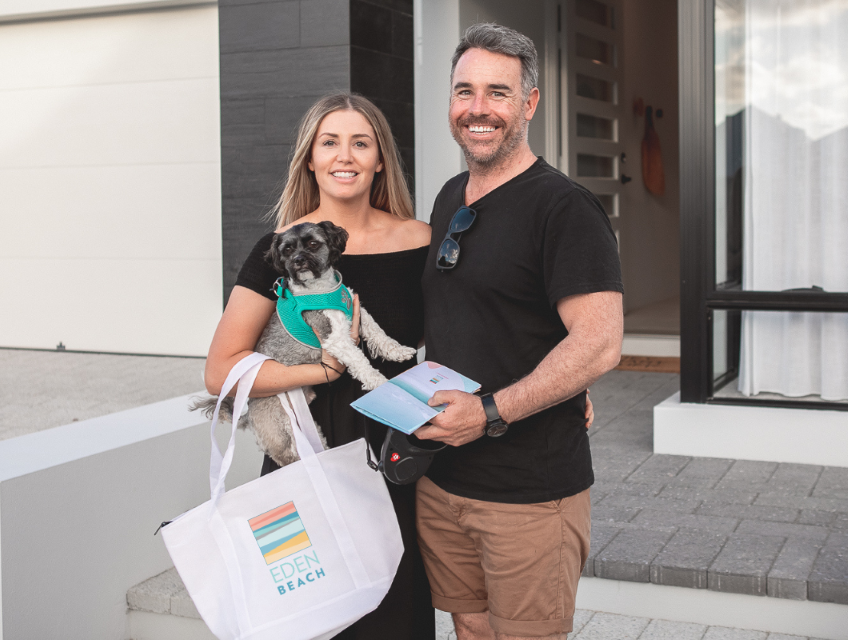 Eden Beach Jindalee Happy couple with dog standing outside display home